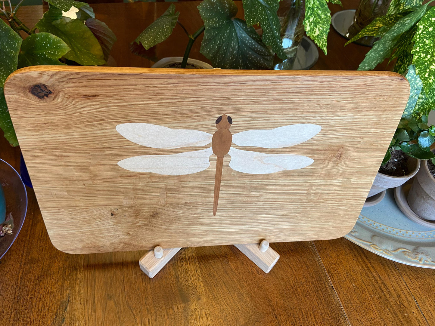 Hand-made art on a wooden canvas.  White Oak charcuterie board; dragonfly inlay of Cherry, Maple and Peruvian Walnut.