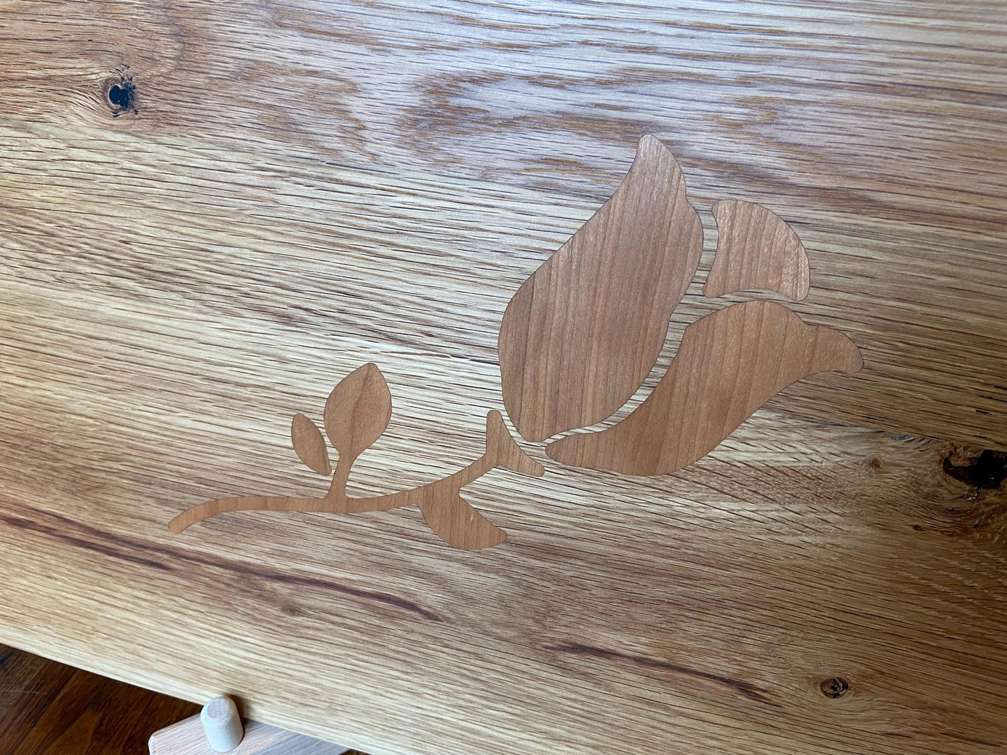 White Oak charcuterie board with subtle rose and stem inlay made from Cherry.