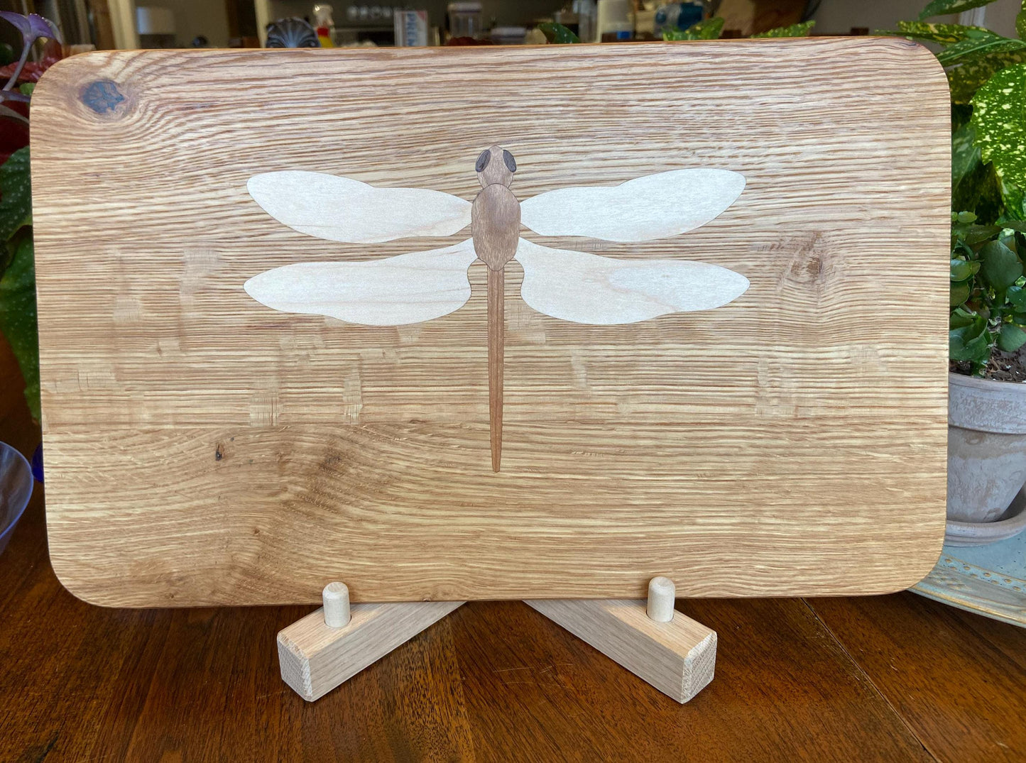 Hand-made art on a wooden canvas.  White Oak charcuterie board; dragonfly inlay of Cherry, Maple and Peruvian Walnut.