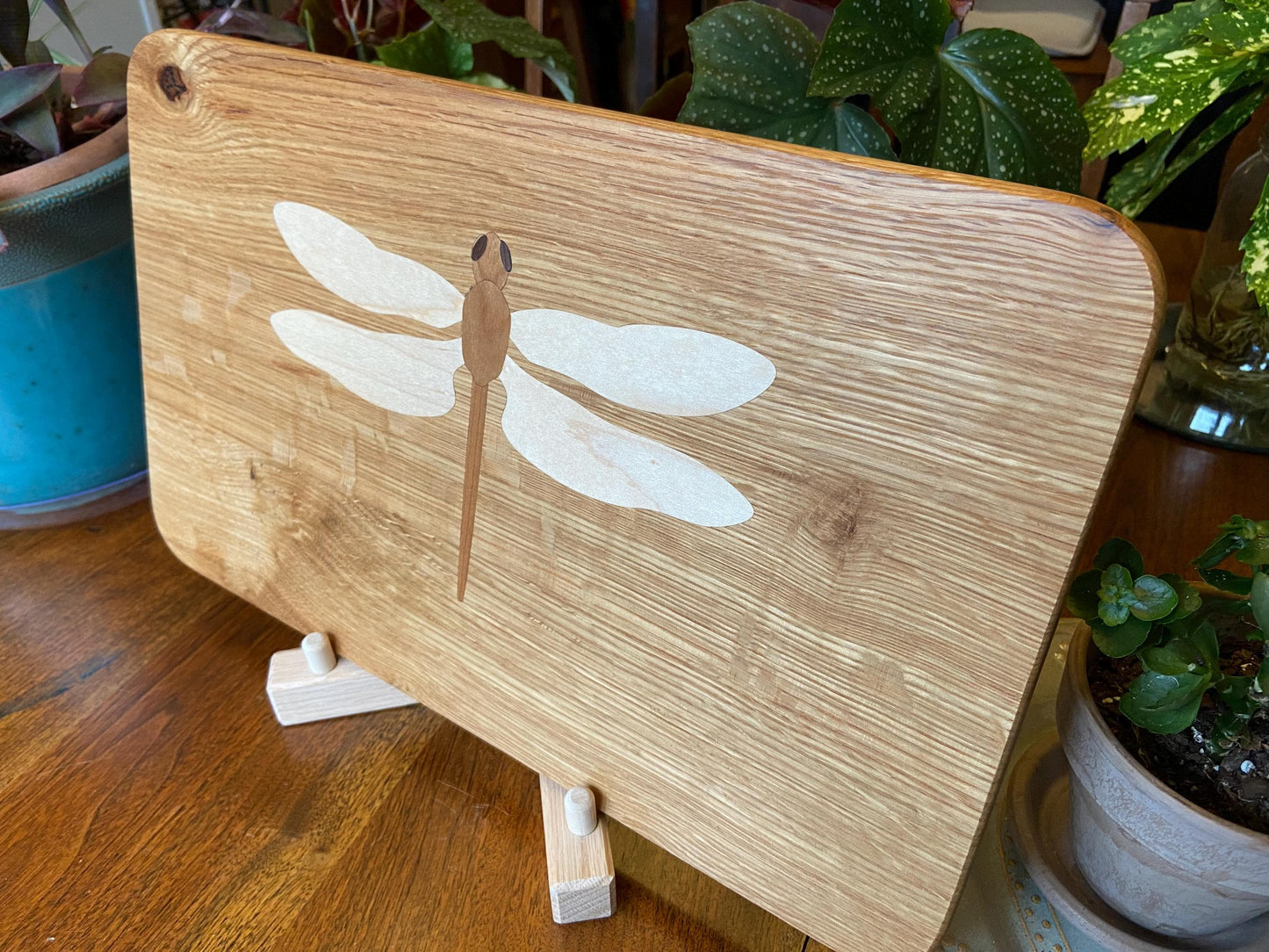 Hand-made art on a wooden canvas.  White Oak charcuterie board; dragonfly inlay of Cherry, Maple and Peruvian Walnut.