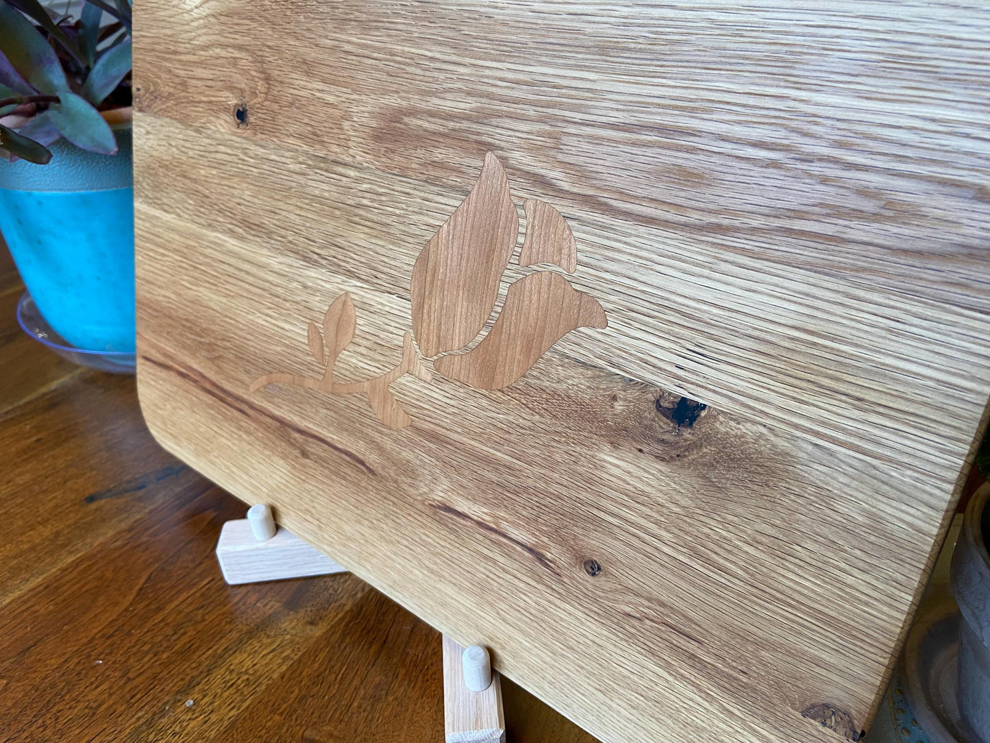 White Oak charcuterie board with subtle rose and stem inlay made from Cherry.