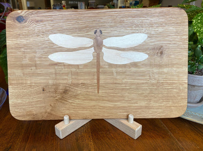Hand-made art on a wooden canvas.  White Oak charcuterie board; dragonfly inlay of Cherry, Maple and Peruvian Walnut.